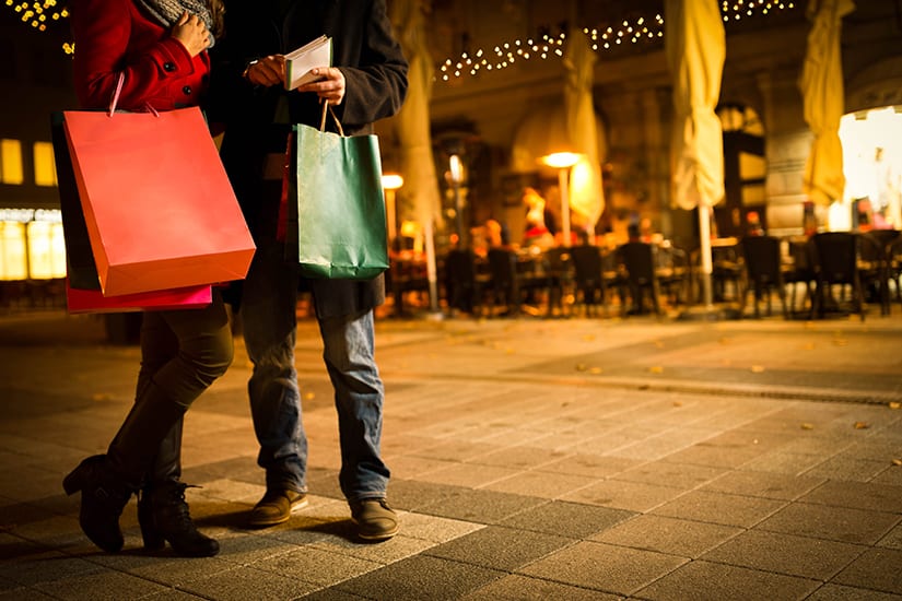 Two Shoppers with Shopping Bags Reviewing Shopping List
