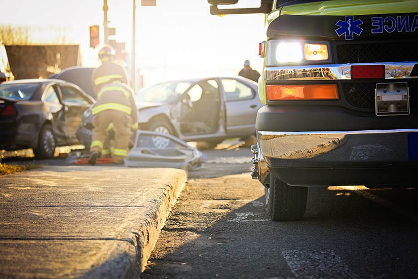 Car Crash Scene With First Responders Assisting The Injured